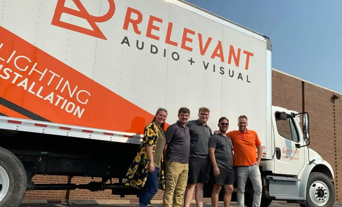 Riverside Wichita small business team in branded shirts with wrapped service vehicle by U.S. Logo