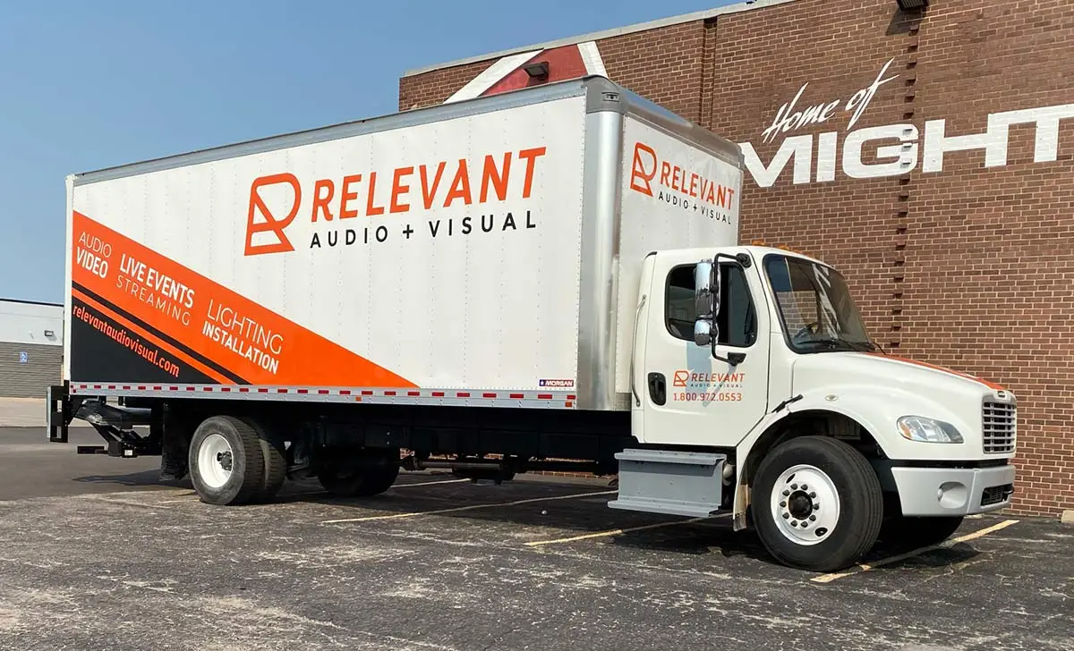 Riverside Wichita small business team in branded shirts with wrapped service vehicle by U.S. Logo